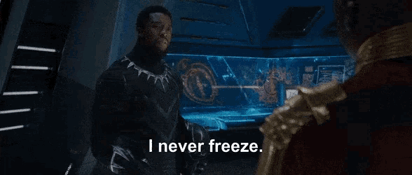 a man in a black suit says i never freeze while standing next to another man