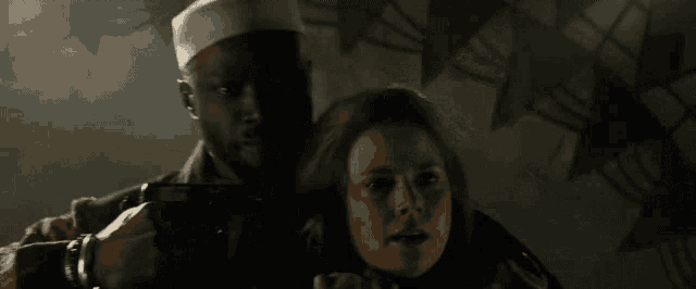 a man holding a gun next to a woman who is crying