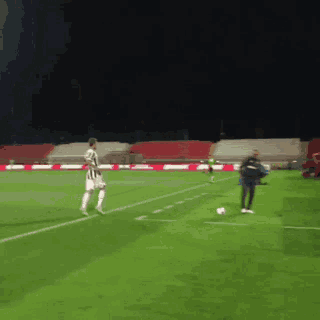 a soccer player in a black and white uniform kicks the ball