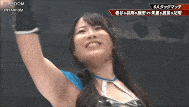 a woman in a stardom wrestling outfit holds her fist up