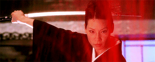 a woman in a kimono is holding a sword .