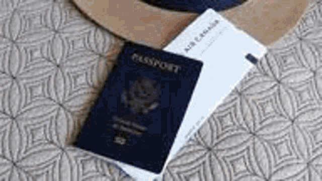 a passport is sitting on top of a piece of paper next to a hat .