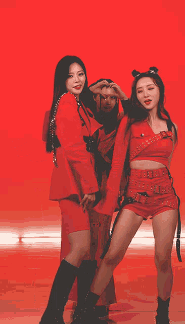 a group of women in red outfits are standing together