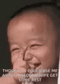 a baby is making a funny face and laughing while holding a glass .