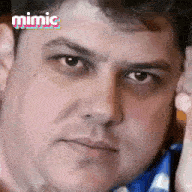 a close up of a man 's face with the word mimic on the bottom right .
