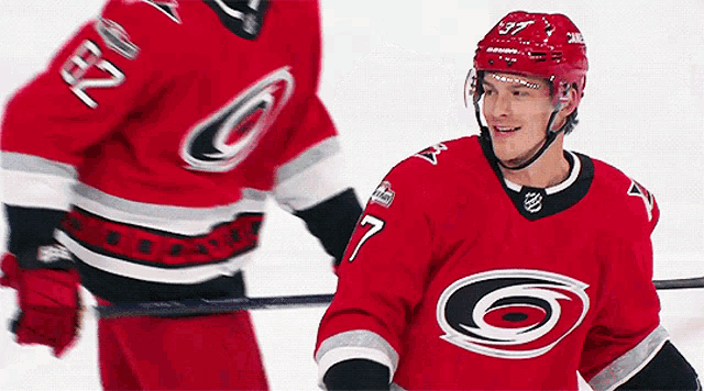 a hockey player with the number 7 on his jersey is standing next to another player