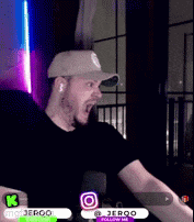 a man wearing a baseball cap and ear buds is making a funny face while playing a video game .