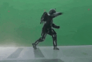 a man in a superhero costume is standing on a green screen .