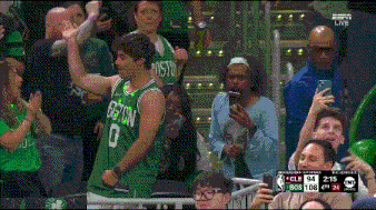 a man in a boston jersey stands in the crowd