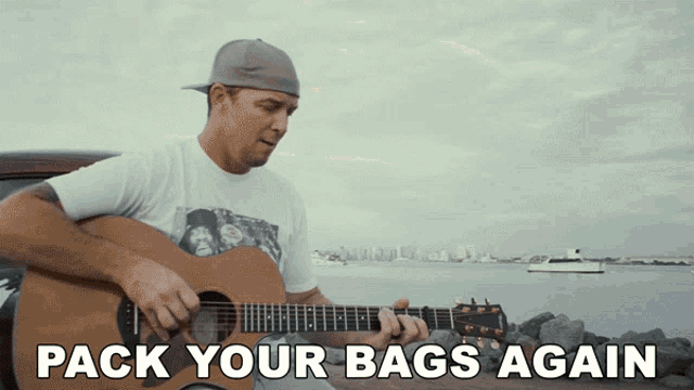 a man is playing a guitar with the words pack your bags again behind him