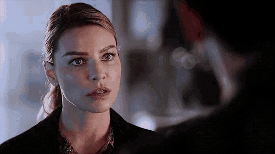a close up of a woman looking at a man in a room .