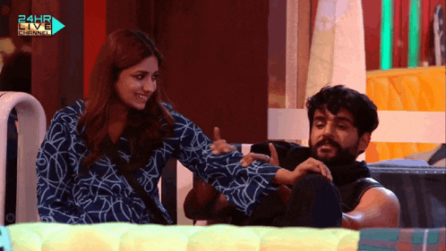 a man and a woman are sitting in front of a 24hr live channel logo