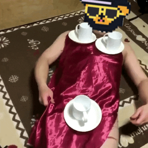 a man in a red dress is laying on the floor with cups and saucers on his chest