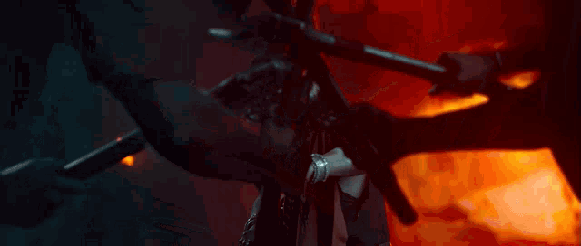 a man holding a sword in front of a fire