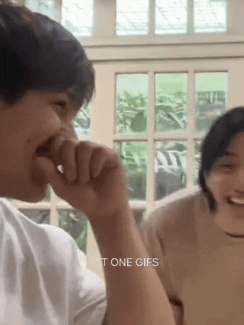 a man and a woman are laughing together in a room .