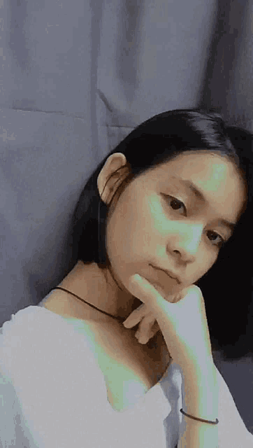 a girl with short hair is taking a selfie with her hand to her chin