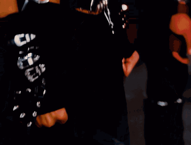 a woman in a black jacket with buckle straps on the shoulder