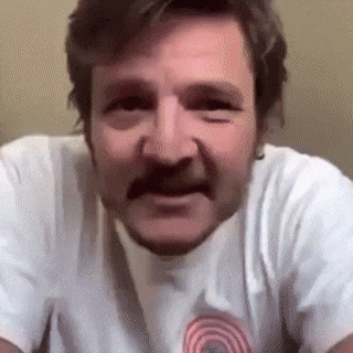a man with a beard and mustache is wearing a white shirt and making a funny face .