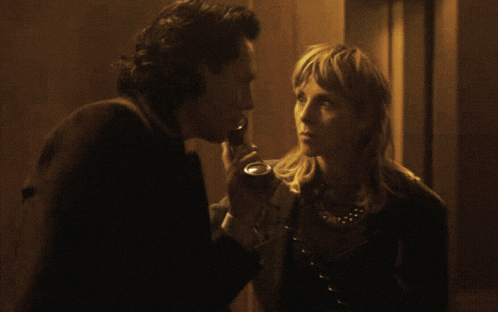 a man and a woman are standing next to each other in a dark room