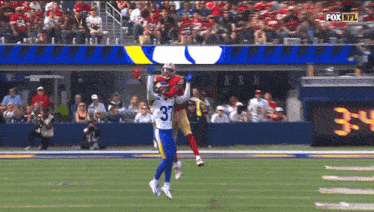 a football player with the number 35 on his jersey catches a ball