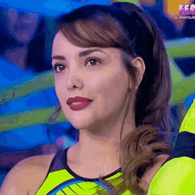 a close up of a woman 's face wearing a yellow tank top and a headband .