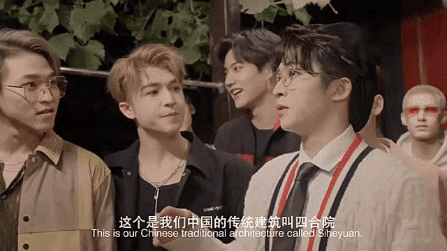 a group of young men are standing next to each other and one of them says this is our chinese traditional architecture