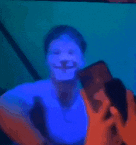 a blurry picture of a person taking a picture with a cell phone