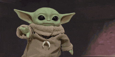a green baby yoda with a crescent moon necklace around his neck