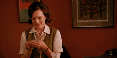 a woman in a green vest and white shirt is smiling while playing cards