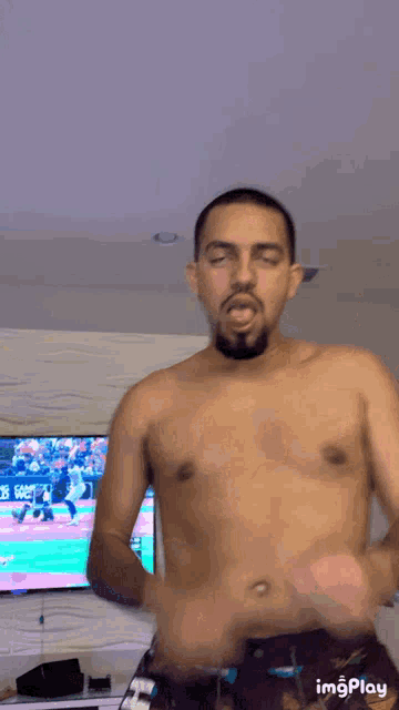 a man without a shirt is dancing in front of a tv with the hashtag imgplay