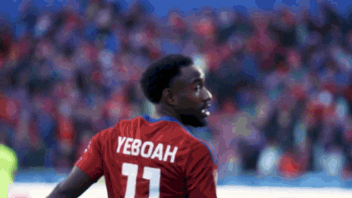 a soccer player wearing a red jersey with the name yeboah on the back
