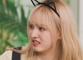 a close up of a woman wearing a cat ear headband making a face .