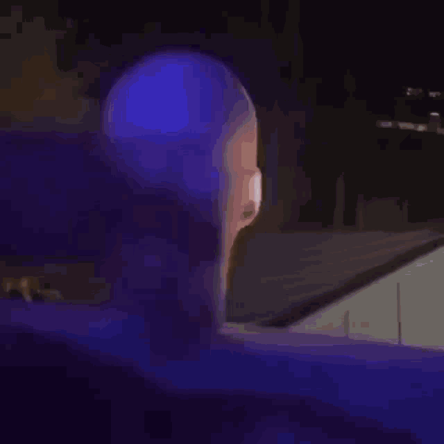 a blurred image of a person 's face with a purple light behind them