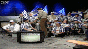 a group of people are watching a soccer game on a tv