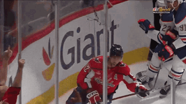 a hockey game is being played in front of a giant ad