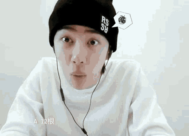 a man wearing a black beanie with rs on it