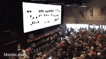 a crowd of people are gathered in front of a large screen that says memix.com on it