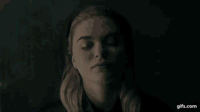 a close up of a woman with her eyes closed in the dark .