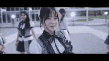 a group of girls are standing next to each other on a sidewalk and smiling .