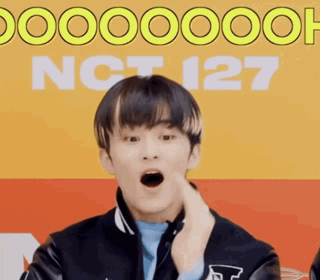 a young man is making a surprised face in front of a yellow and orange background .