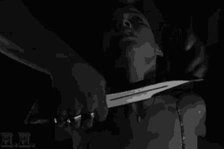 a man is holding a knife over a woman 's neck .