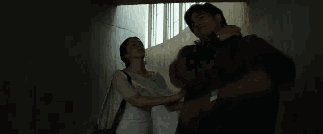 a man and woman kissing in a dark room