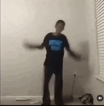 a person is dancing in a room with their arms outstretched .