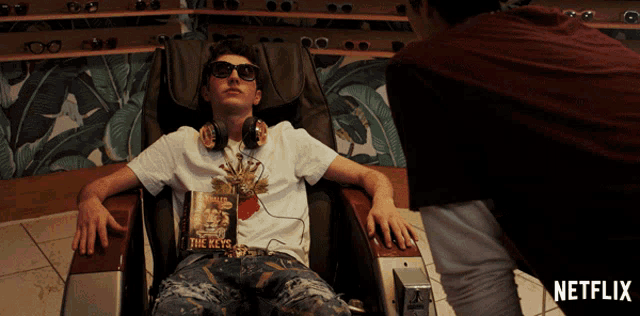 a man laying in a chair with a book titled the keys