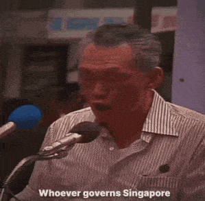 a man in a striped shirt is speaking into a microphone and says must have that iron in him