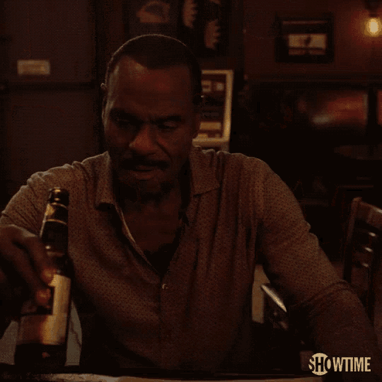 a close up of a man holding a bottle with showtime written on the bottom right