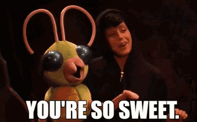 a person is standing next to a stuffed animal that says `` you 're so sweet . ''