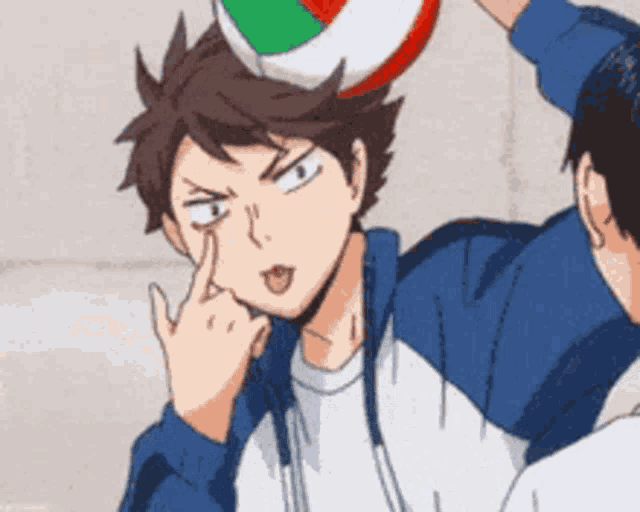 a man is holding a volleyball on top of his head .