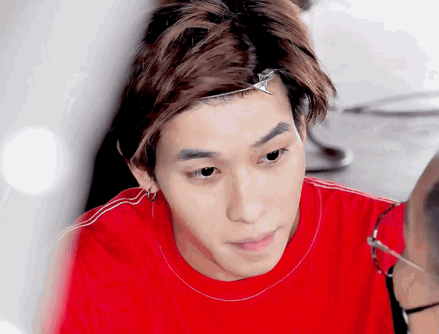 a close up of a person 's face wearing a red shirt