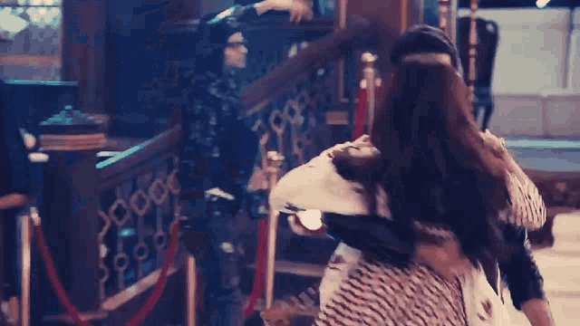 a man is holding a woman in his arms while they are dancing in a room .